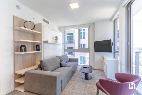 a living room with a couch and a tv at Downtown Miami Condos by Lua Host in Miami
