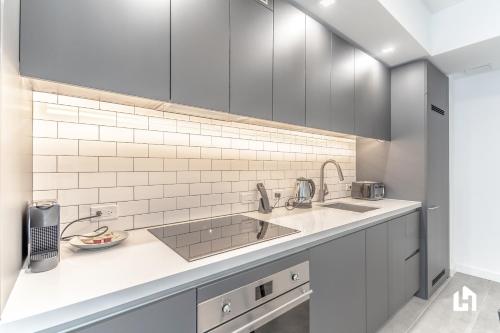 a kitchen with white cabinets and a sink at Downtown Miami Condos by Lua Host in Miami