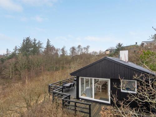 Ein schwarzes Haus an der Seite eines Hügels. in der Unterkunft Holiday Home Heera - 100m to the inlet in The Liim Fiord by Interhome in Lihme