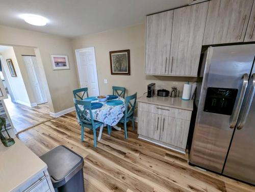 a kitchen with a table with chairs and a refrigerator at Modern & Comfy Lagoon Oasis - River Views - Parking in Titusville