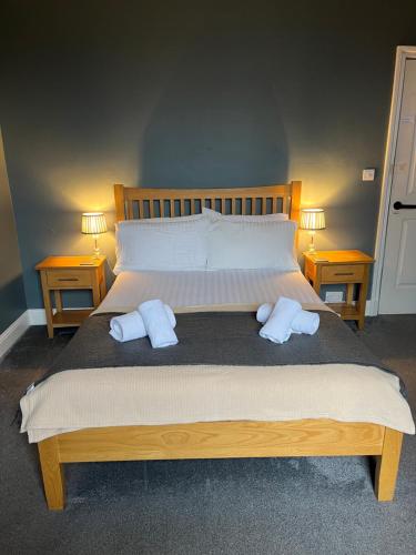 a bedroom with a large bed with two pillows on it at Ambleside Central in Ambleside