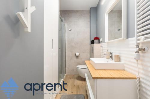a bathroom with a toilet and a sink and a shower at Apartament AURI Pobierowo Baltic Apartments - Aprent in Pobierowo