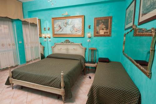 a bedroom with two beds and blue walls at B&B Babri Simim Taj in Rome