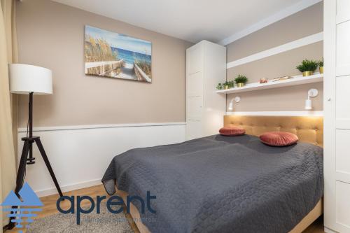 a bedroom with a bed with red pillows on it at Apartament AURI Pobierowo Baltic Apartments - Aprent in Pobierowo