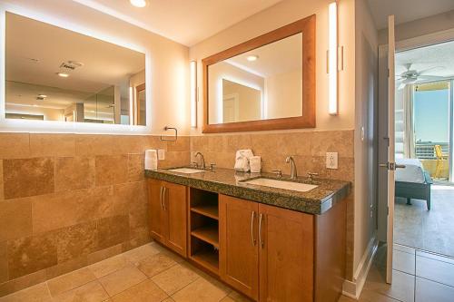 uma casa de banho com 2 lavatórios e um espelho grande em Ocean Club 1206 em Biloxi