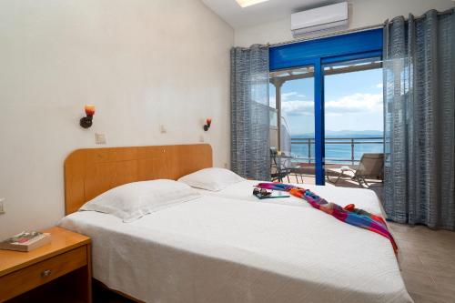 a bedroom with a bed with a view of the ocean at Minos Boutique Hotel in Agia Galini