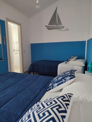 two beds in a bedroom with a sail on the wall at B&B Fradama' Holiday in Dorgali