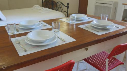 a wooden table with plates and dishes on it at Italianway - Piazza Campidoglio 3 in Lenno
