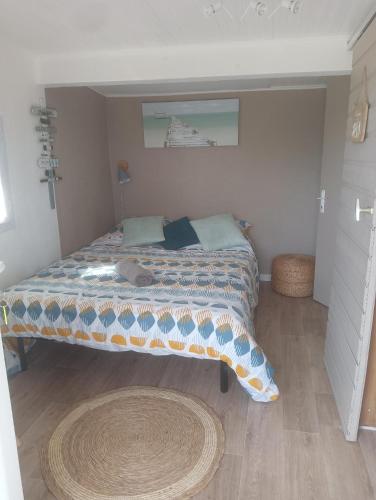 1 dormitorio con cama con edredón en La Chouette Villa, chambre Mazet de 11m2 pièce sous-pente accés par escalier en bois en Cannes-et-Clairan