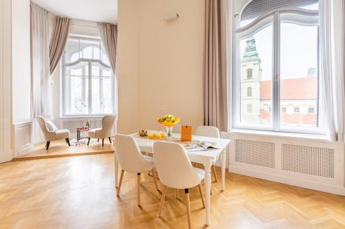 comedor con mesa y sillas y ventana grande en Matilda Luxury Suite Apartment en Budapest