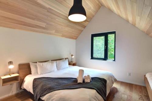1 dormitorio con 1 cama grande en el ático en 1 Impasse du Cardinal - Lac Superior Chalet w Spa Sauna & Games Room en Mont-Tremblant