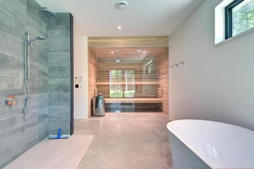a bathroom with a shower and a bath tub at 1 Impasse du Cardinal - Lac Superior Chalet w Spa Sauna & Games Room in Mont-Tremblant