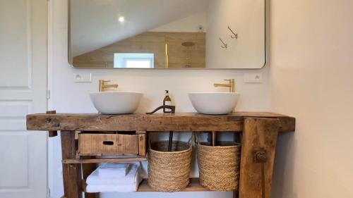 ein Badezimmer mit zwei Waschbecken auf einem Holztisch in der Unterkunft La Millière - Chambres d'hôtes in Le Poiré-sur-Vie