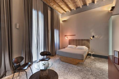 1 dormitorio con 1 cama, mesa y sillas en Palazzo Calò, en Bari