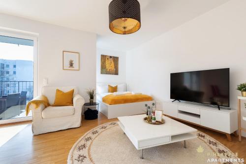 uma sala de estar branca com uma televisão e um sofá em Pineapple Apartments Dresden Zwinger II - 70 qm - 1x free parking em Dresden
