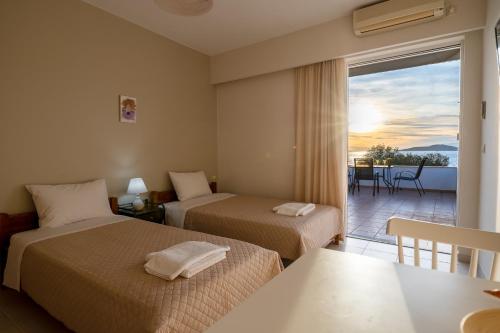 a hotel room with two beds and a balcony at Ο Μόλος in Marmarion