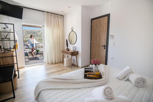 Un dormitorio con una cama grande y una mujer caminando en un balcón en Olive Forest Villa, en Koxaré