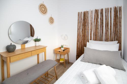 una camera con letto, specchio e panca di Olive Forest Villa a Koxaré