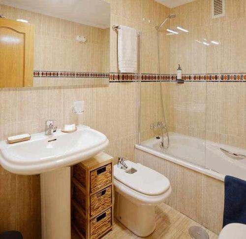 ein Badezimmer mit einem Waschbecken, einem WC und einer Badewanne in der Unterkunft La Plazuela Urban Estudio in Gijón