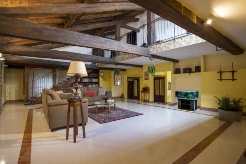 Residenza Bianconcini في بولونيا: غرفة معيشة كبيرة بسقوف خشبية وتلفزيون
