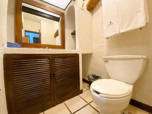 La salle de bains est pourvue de toilettes et d'un miroir. dans l'établissement Puerto de Luna Pet Friendly and Family Suites, à Puerto Vallarta