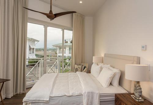a bedroom with a large bed and a large window at Marina Pez Vela Villas in Quepos