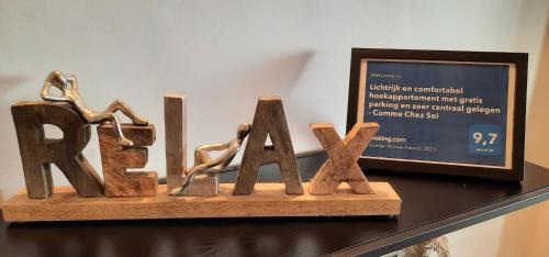 a wooden sign for the word rave on a shelf at Lichtrijk en comfortabel hoekappartement met gratis parking en zeer centraal gelegen - Comme Chez Soi in Ostend