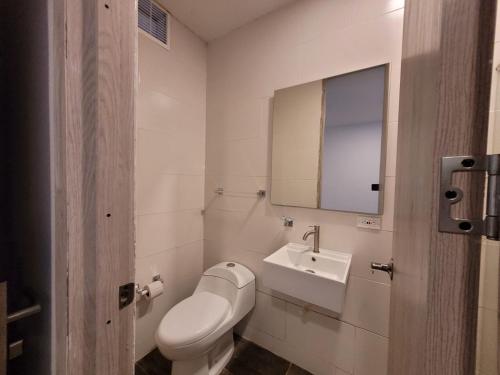 San AlbertoにあるHOTEL COLOMBIA BYBのトイレ、洗面台、鏡を備えたバスルーム