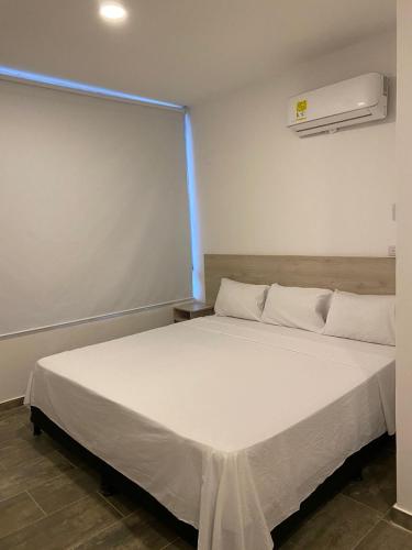 a bedroom with a large white bed in a room at HOTEL COLOMBIA BYB in San Alberto