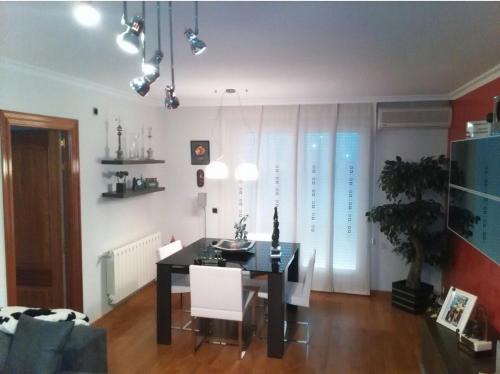 ein Esszimmer mit einem schwarzen Tisch und weißen Stühlen in der Unterkunft Buenos Aires apartamento in Guadix
