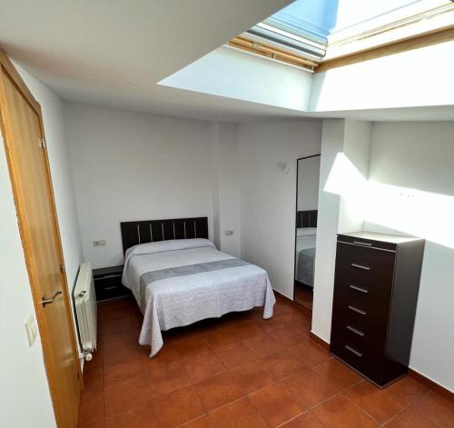 1 dormitorio con 1 cama y tragaluz en El Cielo De Mogarraz en Mogarraz