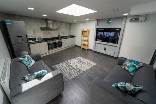 a living room with two couches and a kitchen at STAY SA Equipped Studios 10 mins from City centre and next to UOB! in Birmingham