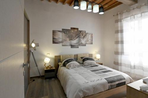 1 dormitorio con 1 cama y 2 cuadros en la pared en L'Antico Camino - Alloggio Turistico, en Acquapendente