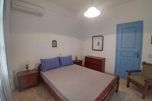 een slaapkamer met een bed en een blauwe deur bij Bella Vista in Síkinos