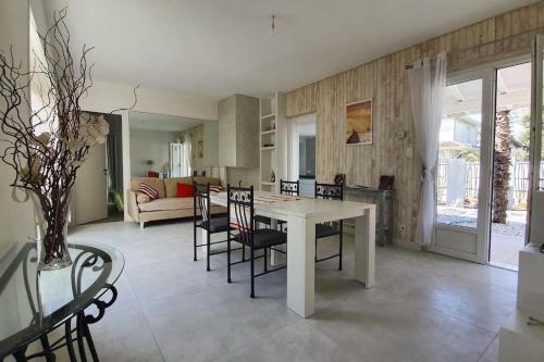 a kitchen and living room with a table and chairs at BRUYERES - Capbreton, belle villa spacieuse entre ville et plages au calme in Capbreton