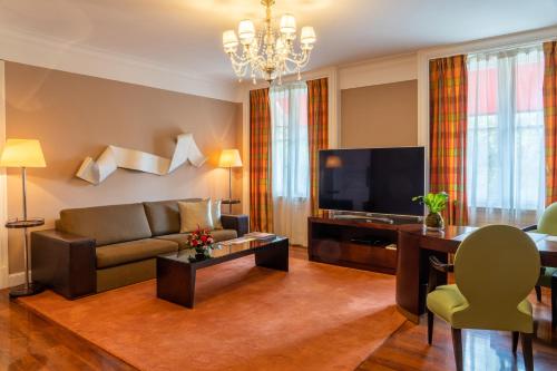 a living room with a couch and a television at Palacio Duhau - Park Hyatt Buenos Aires in Buenos Aires