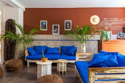 a living room with blue couches and plants at Casa Mara Dakar in Dakar