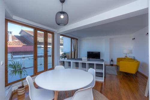 a living room with a white table and chairs at Alta Guesthouse in Coimbra