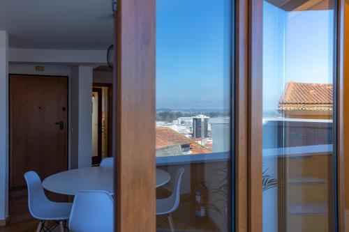 a room with a table and a view of a city at Alta Guesthouse in Coimbra