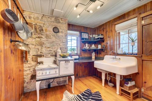 cocina con fregadero y pared de piedra en Historic Tennessee Vacation Rental on Homestead, en Crossville