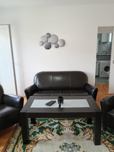 a living room with a leather couch and a table at Nikolici - Free Parking in Vranje