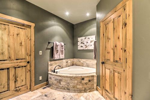 a bathroom with a tub in a room with wooden doors at Beautiful Eureka Cabin Rental on Golf Resort! in Eureka