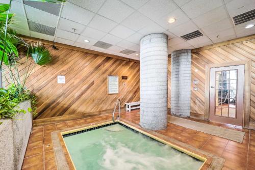 una piscina d'acqua in una stanza con pavimenti e colonne in legno di 3 Mi to Sugar Mountain Resort Condo with Balcony! a Sugar Mountain