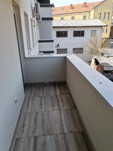 a balcony with a wooden floor in a building at Nikolici - Free Parking in Vranje