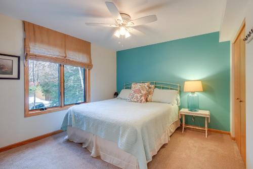 a bedroom with a bed and a ceiling fan at Elk Rapids Condo with Balcony Overlooking Elk Lake! in Elk Rapids