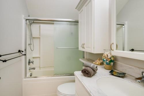 a bathroom with a sink and a toilet and a shower at Elk Rapids Condo with Balcony Overlooking Elk Lake! in Elk Rapids
