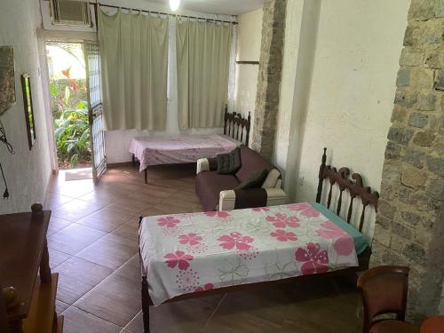 um quarto com duas camas e uma mesa e uma janela em Rio Natureza apart 106 no Rio de Janeiro