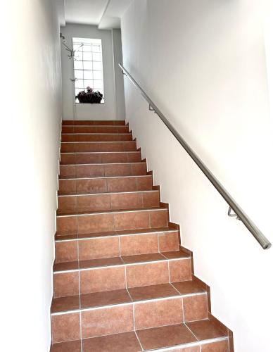 a staircase with brown tile floors and a window at Apartment Lady Daniela mit Meerblick in Lovran in Lovran