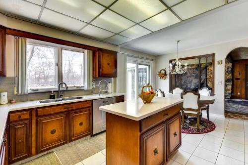 a kitchen with wooden cabinets and a dining room at Spacious Buffalo Brick Home w/ Backyard! in Buffalo