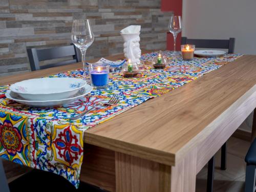 a wooden table with a table cloth with a plate on it at Flower House in Santo Stefano di Camastra
